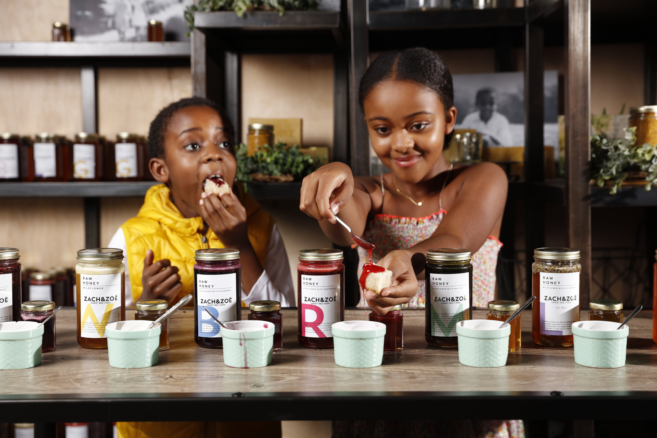 two kids holding up honey jars 