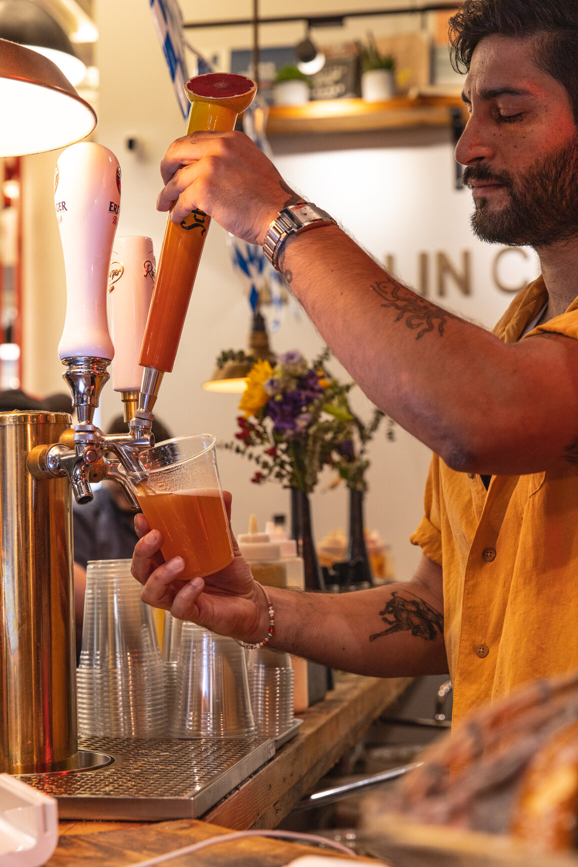 man pouring beer from a tap 