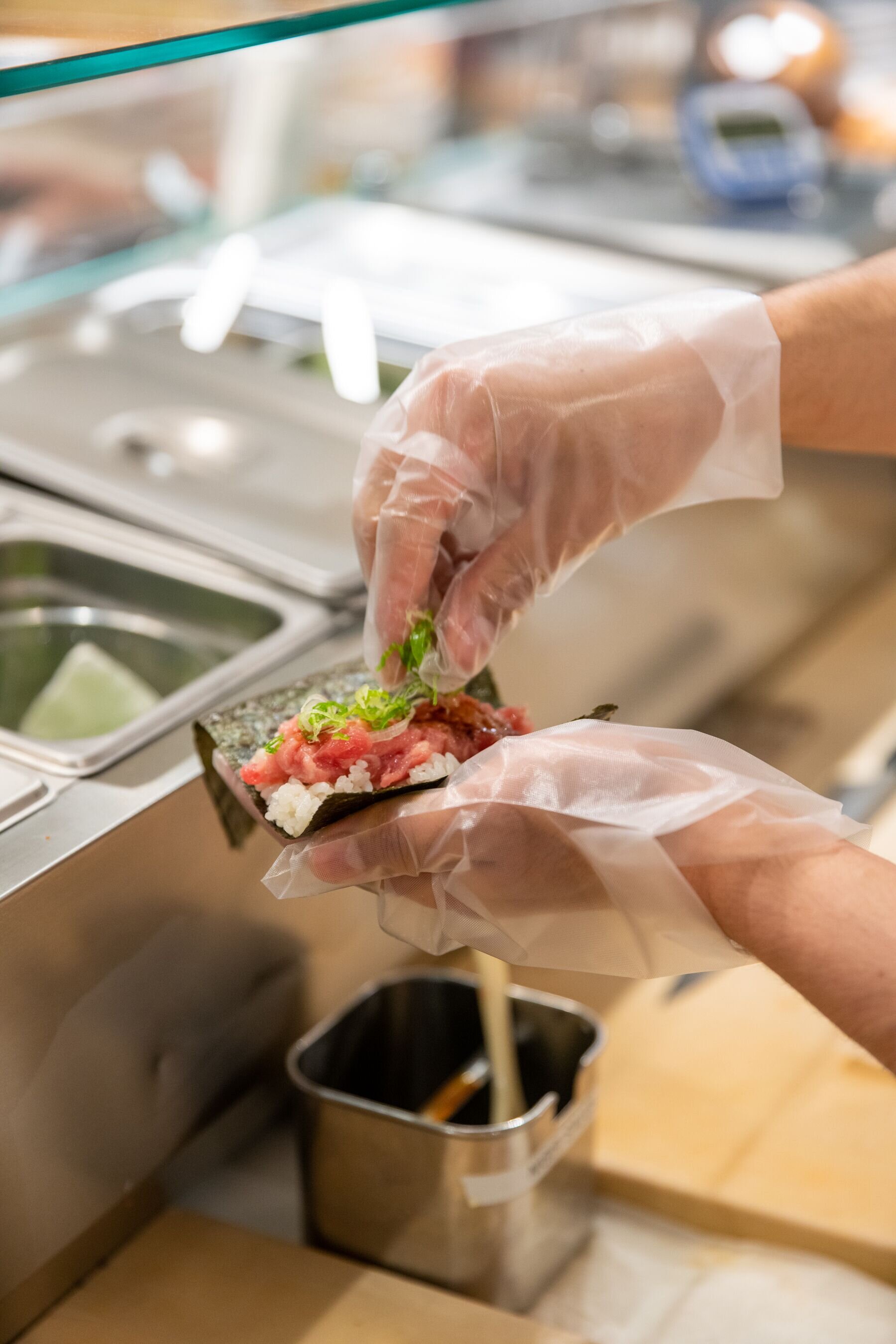 tuna sushi hand roll being made 