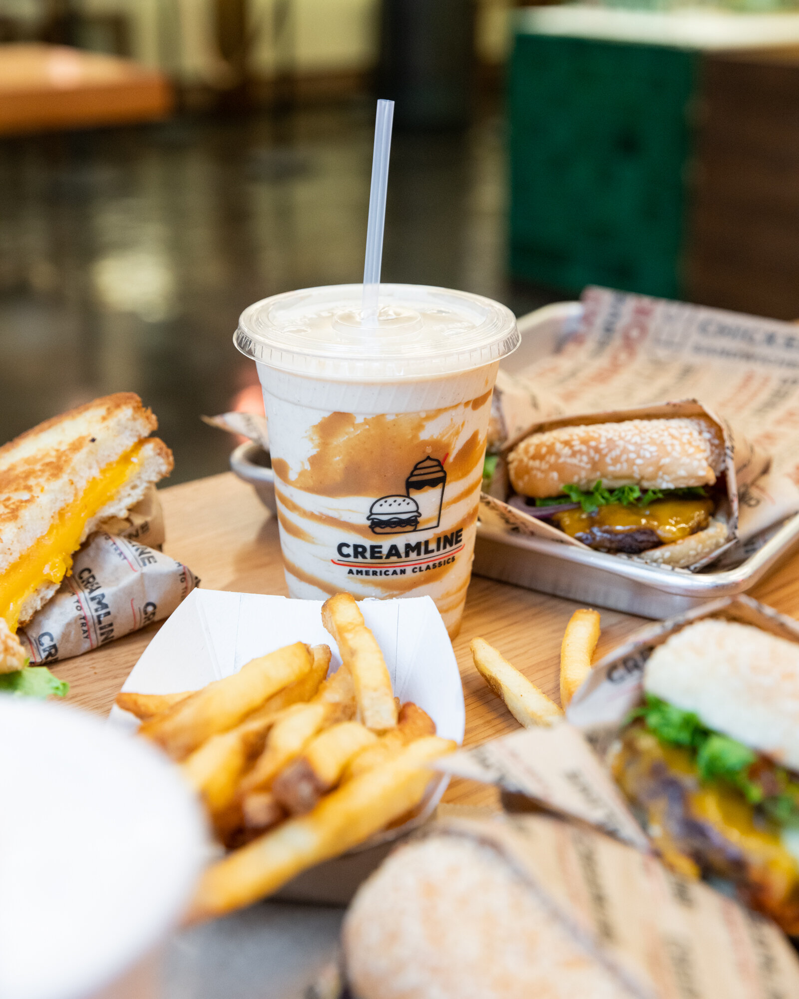 Trays with hamburgers, a milk shake, fries on at table