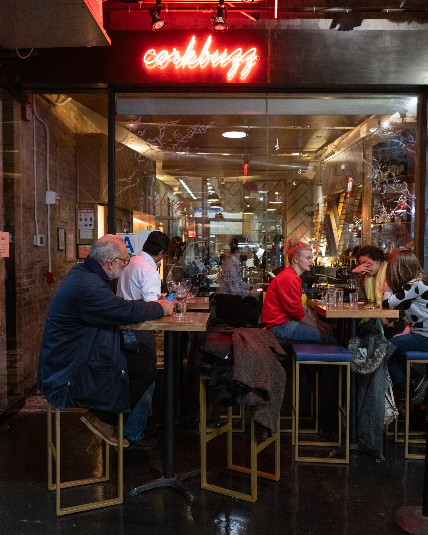 exterior of corkbuzz with people sitting at a table 