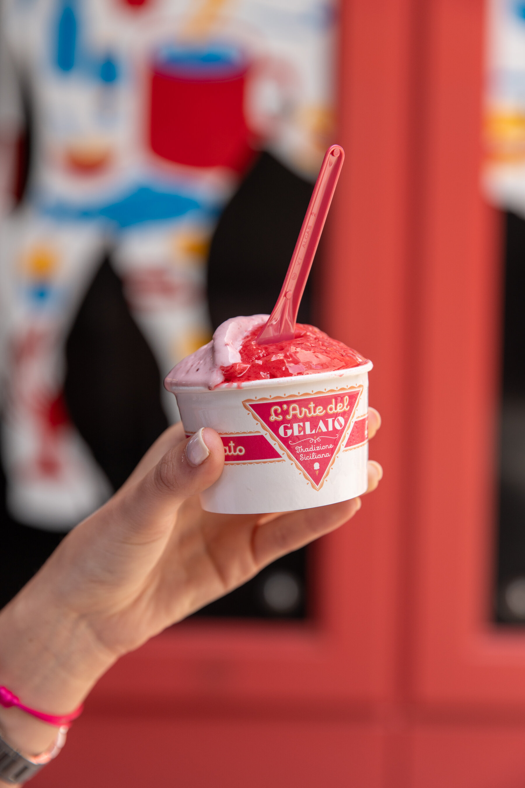 hand holding a cup of gelato outside 