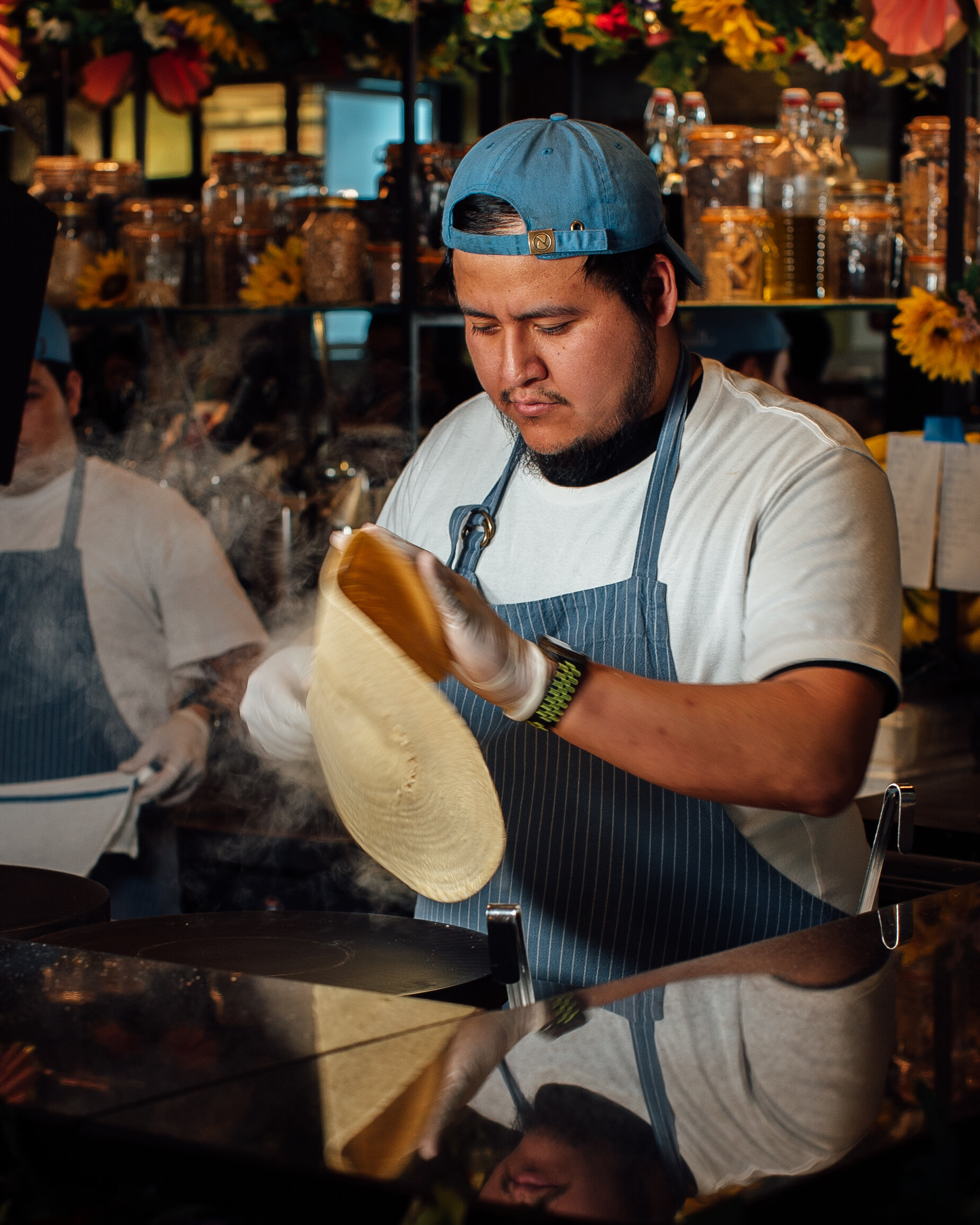 man flipping crepe on griddle