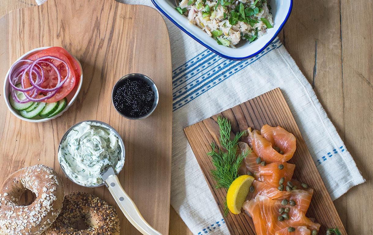 overhead shot of bagel, lox, schemer, tomatoes and onion